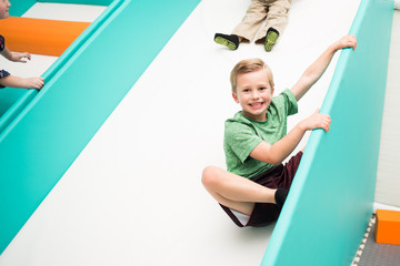 Happy Boy sliding down indoor slide
