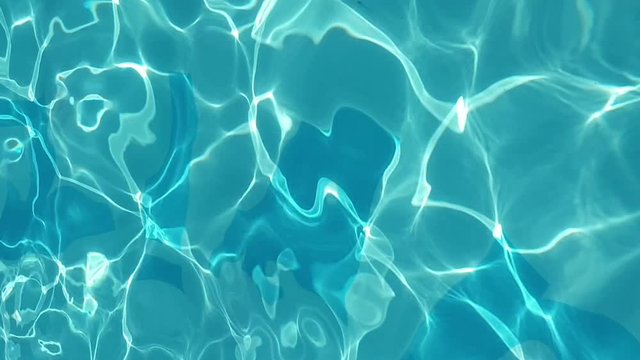 Blue water in swimming pool with sun reflection. Bright wave in the pool