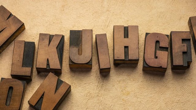 Alphabet or follow the leader concept - stop motion animation with vintage letterpress wood type block against handmade bark paper.