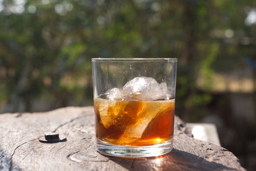 glass of whiskey on wood.