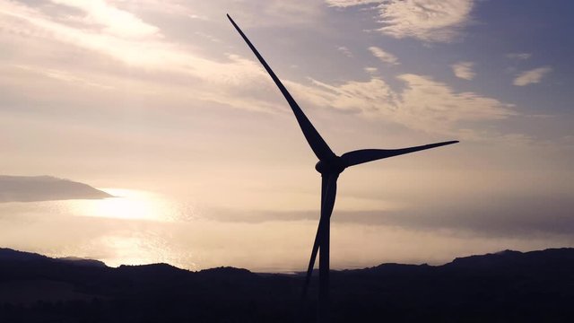 Wind turbine silhouette rotating at sunset. Aerial footage. Spain