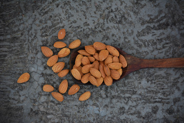 Dried almond nuts in wooden spoon