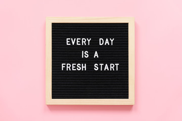 Every day is a fresh start. Motivational quote on black letter board on pink background. Concept...