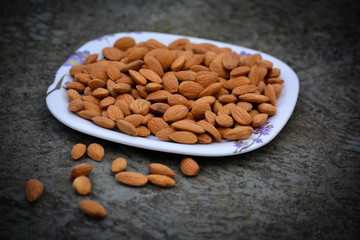 Almonds on a plate. Almonds are healthiest nuts and one of the best brain foods.