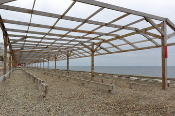 wooden canopy on the sea pebble beach in winter