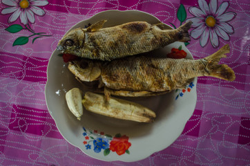 pescado en un plato con flores frito