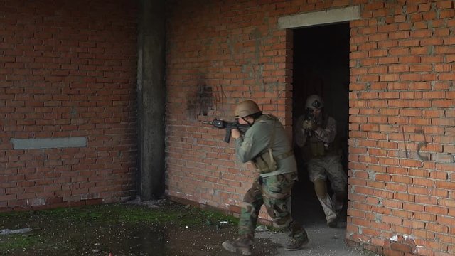 Militias are fighting. Group of soldiers in camouflage with guns and playing airsoft.