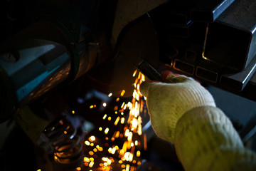 Metal cutting. Grinding steel. Work as a grinder. Sparks from friction. Men's work. Creating a...