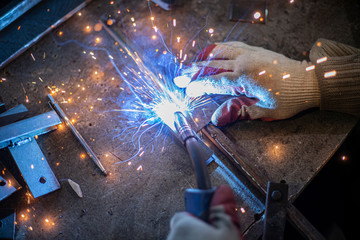 Metal welding. Sparks from electric heating. Work in the workshop. Creation of reliable fastening...