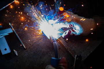Metal welding. Sparks from electric heating. Work in the workshop. Creation of reliable fastening...