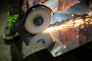 Metal cutting. Grinding steel. Work as a grinder. Sparks from friction. Men's work. Creating a...