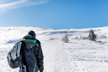 Fototapeta na wymiar Man in the High Snowy Mountain .Winter Vacation Concept 