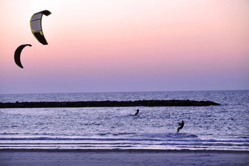 Kitesurfers surfing at sunset over the Mediterranean sea in Tel Aviv Israel