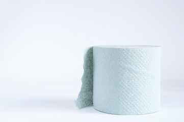 A roll of toilet paper lies on the table. On white background
