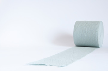 A roll of toilet paper lies on the table. On white background