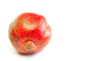 Red ripe pomegranate lies on a table on a white background.