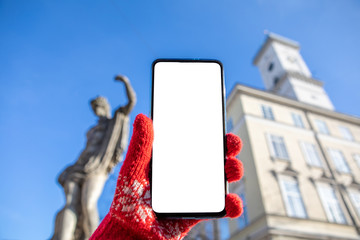 woman hand in red gloves holding phone with white screen lviv city hall on background