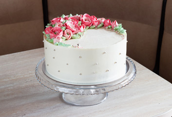 Obraz na płótnie Canvas white round cake with cream flowers on the table