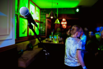Public performance on stage Microphone on stage against a background of auditorium. Shallow depth of field. Public performance on stage.