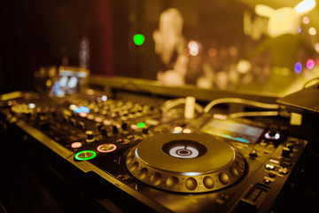 Fototapeta na wymiar DJ Spinning, Mixing, and Scratching in a Night Club, Hands of dj tweak various track controls on dj