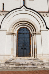 Naklejka premium Ancient russian architecture. Close-up of arched metal door in russian style