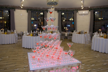 A pile of champagne glasses at a party. Alcoholic luxury pyramid of wineglass.