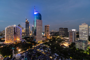 Fototapeta na wymiar Stunning twilight over the Jakarta downtown distirct skyline, which contrast with low rise houses, in Indonesia capital city