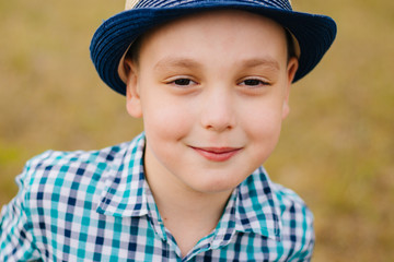 Portrait of a boy in a hat. Baby girl in a blue shirt in a cage in the field. Walk in nature