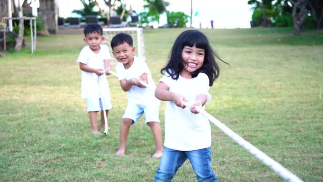 Kid teamwork and competition concept.  Happy Children play tug of war with unity and teamwork.