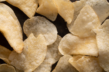 Potato chips scattered on table .