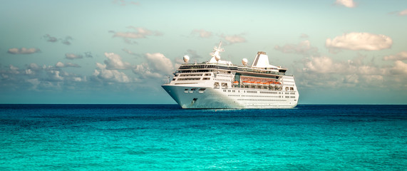 Cruise ship sailing on the Caribbean Sea. Side view of the vessel. Wide image.