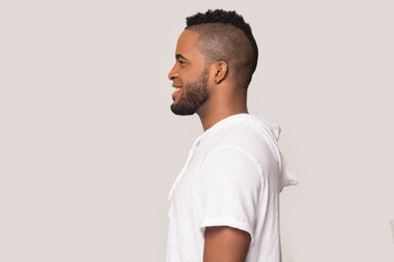 Smiling black man stand in profile isolated in studio