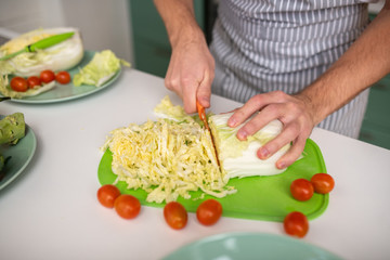 Cook cutting cabbage for a vegetable salad