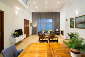 Modern interior of living room in private house. View of wall with big window. Furniture.