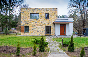 Modern design of private house. An exterior of two-storey building. Autumn day. Front view.