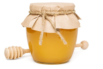 Natural homemade honey in a glass jar with paper and linen rope, wooden spoon