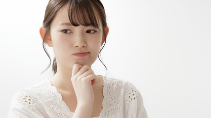 若い女性　考える　悩む
