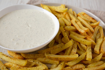 Homemade Crispy Ranch Fries on a gray plate, side view. Close-up.