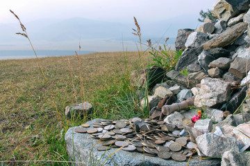 Offerings (mostly coins) to the spirits of the mountain pass. Altai mountains, Altai Republic, Siberia, Russia.