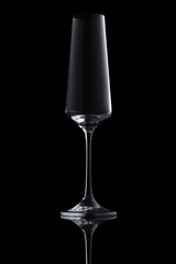 Single empty elegant luxury transparent clear champagne glass with gradient highlight isolated on black background. Design element with clipping path.