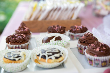 A closeup of chocolate cupcakes on the table under the lights with a blurred background