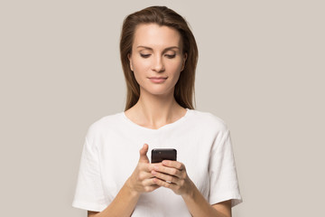 Fototapeta premium Young woman using cellphone messaging or browsing internet