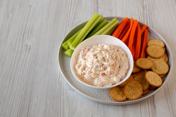 Homemade Pimento Cheese Dip with carrots, celery and crackers, side view. Copy space.