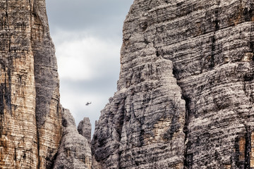 Helicopter flying near the Three Peaks in the Dolomite Alps, South Tyrol, Italy