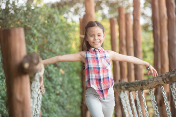 Obraz premium happy little asian girl child having fun to playing in the playground in summer time with smile and laughing healthy, funny smiling face adorable lovely female kid. happy vacation lifestyle concept.