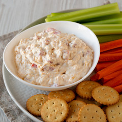 Homemade Pimento Cheese Dip with carrots, celery and crackers, low angle view. Close-up.