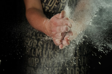 women's hands sift the flour