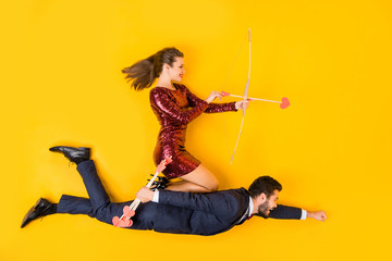 Top above high angle view full size profile side photo two people woman sit spine man fly superman aim shoot cupid arrow blow 14-february dress tux suit lay isolated shine color background