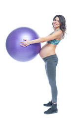 Fototapeta premium Portrait of a beautiful young pregnant woman exercises with fitball. Working out and fitness, pregnancy concept. Isolated white background.