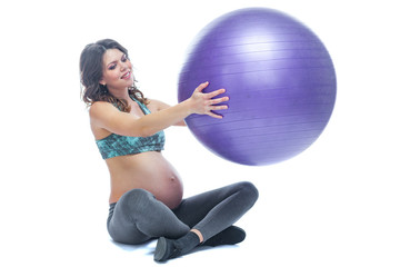Fototapeta premium Portrait of a beautiful young pregnant woman exercises with fitball. Working out and fitness, pregnancy concept. Isolated white background.